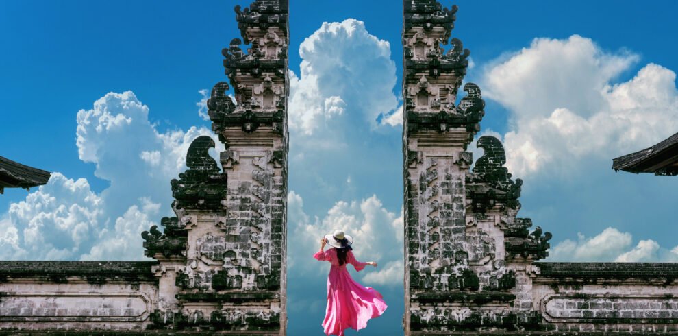 Young woman standing in temple gates at Lempuyang Luhur temple i